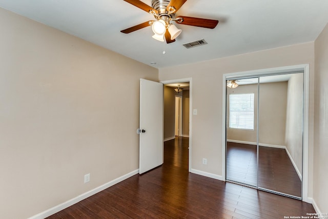 unfurnished bedroom with ceiling fan, dark hardwood / wood-style floors, and a closet