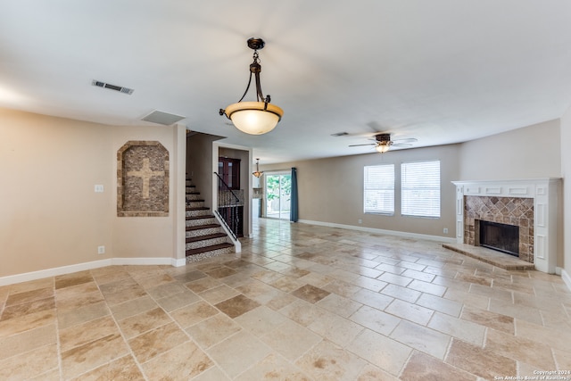 unfurnished living room featuring a fireplace, light tile patterned floors, and ceiling fan