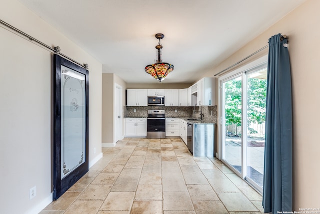 kitchen featuring tasteful backsplash, stainless steel appliances, white cabinets, pendant lighting, and light tile patterned flooring