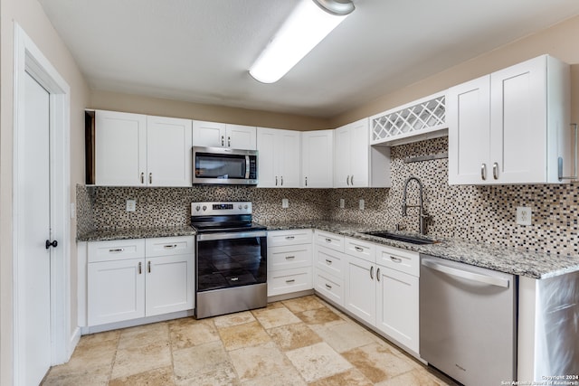 kitchen featuring appliances with stainless steel finishes, white cabinetry, and sink