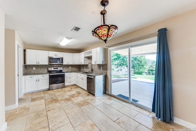 kitchen featuring sink, tasteful backsplash, decorative light fixtures, appliances with stainless steel finishes, and white cabinets