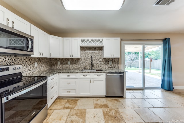 kitchen with decorative backsplash, stainless steel appliances, sink, and white cabinets