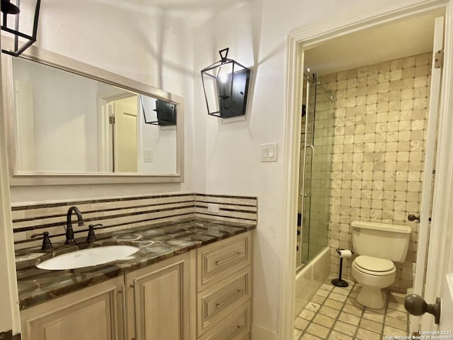 full bathroom with vanity, backsplash, enclosed tub / shower combo, and toilet