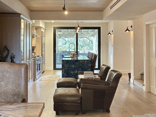 living room with sink, wooden ceiling, and light wood-type flooring