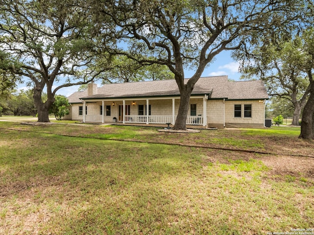 143 Cascade Caverns, Boerne, TX 78015 - single story home with central AC unit, covered porch, a shingled roof, a chimney, and a front lawn