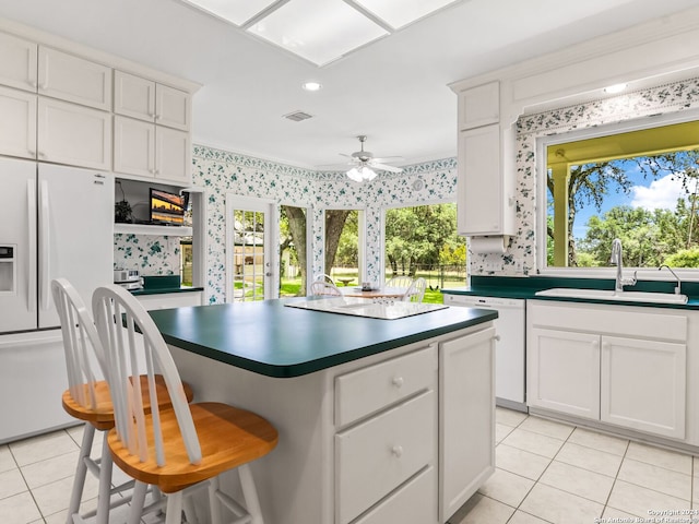 143 Cascade Caverns, Boerne, TX 78015 - kitchen featuring visible vents, a sink, a kitchen island, white appliances, and light tile patterned floors