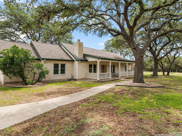 143 Cascade Caverns, Boerne, TX 78015 - view of front of property featuring a front yard, a porch, a chimney, and a shingled roof