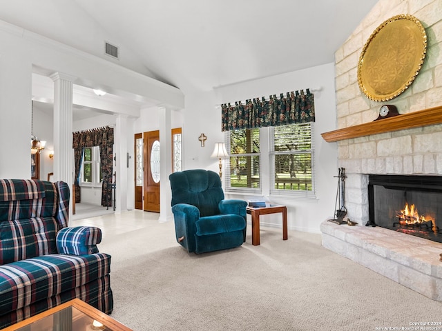 carpeted living room featuring ornate columns, a fireplace, and vaulted ceiling