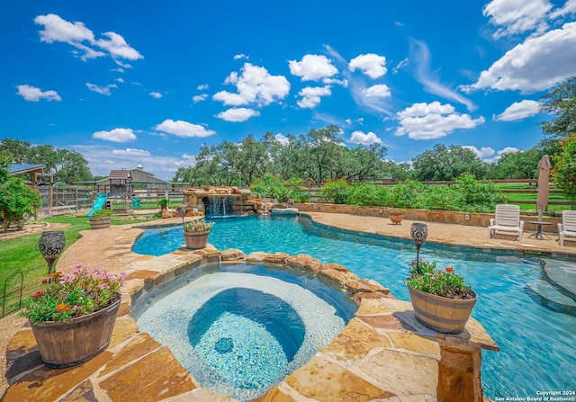 view of pool with an in ground hot tub and pool water feature