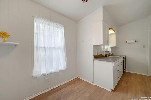 kitchen with white cabinetry, light hardwood / wood-style floors, and sink