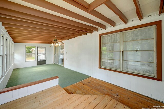 unfurnished sunroom featuring beamed ceiling