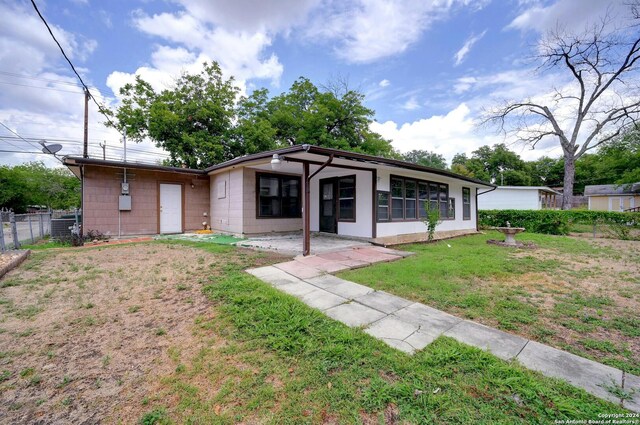 view of front of property featuring a front lawn and a patio area