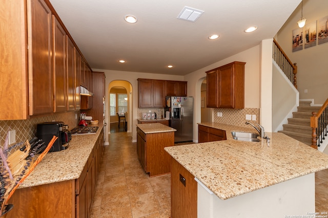 kitchen featuring tasteful backsplash, light tile patterned floors, kitchen peninsula, appliances with stainless steel finishes, and sink