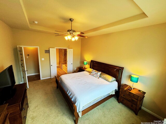 bedroom with ceiling fan, carpet, and a tray ceiling