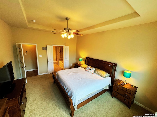 bedroom with ceiling fan, a tray ceiling, and carpet floors