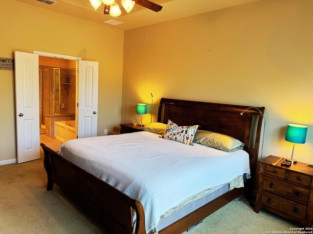 bedroom featuring ensuite bathroom, carpet, and ceiling fan