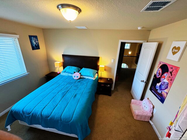 carpeted bedroom featuring a textured ceiling