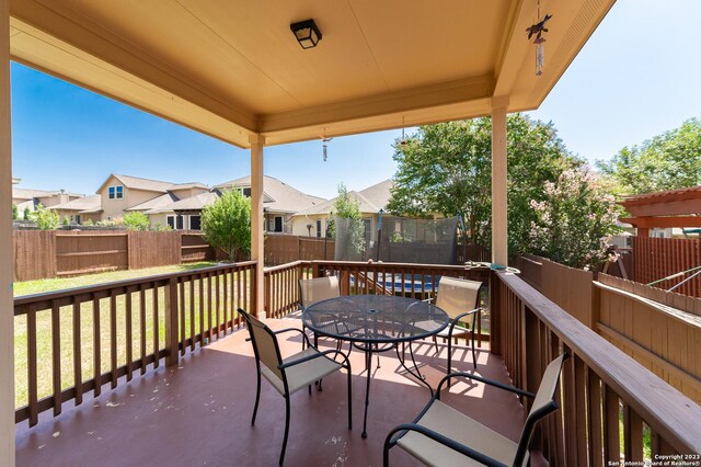 view of patio / terrace with a trampoline and a wooden deck