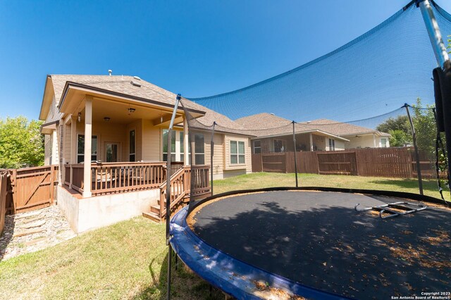 back of house featuring a wooden deck and a lawn