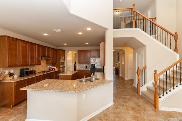 kitchen featuring light tile patterned flooring, stainless steel appliances, sink, kitchen peninsula, and backsplash