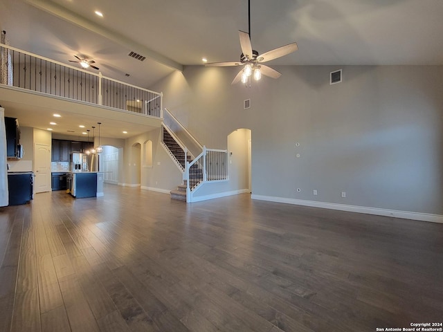 unfurnished living room featuring ceiling fan, high vaulted ceiling, beam ceiling, and dark hardwood / wood-style floors