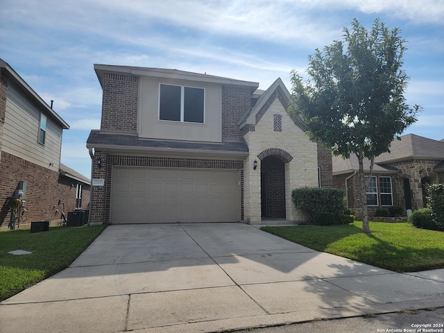 view of front of property featuring a garage, a front yard, and central air condition unit