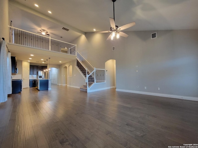 unfurnished living room with dark wood-type flooring, beam ceiling, high vaulted ceiling, and ceiling fan