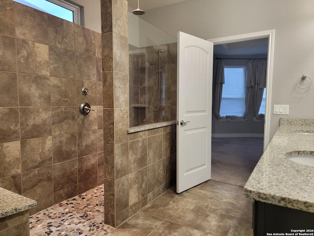 bathroom featuring a tile shower and vanity