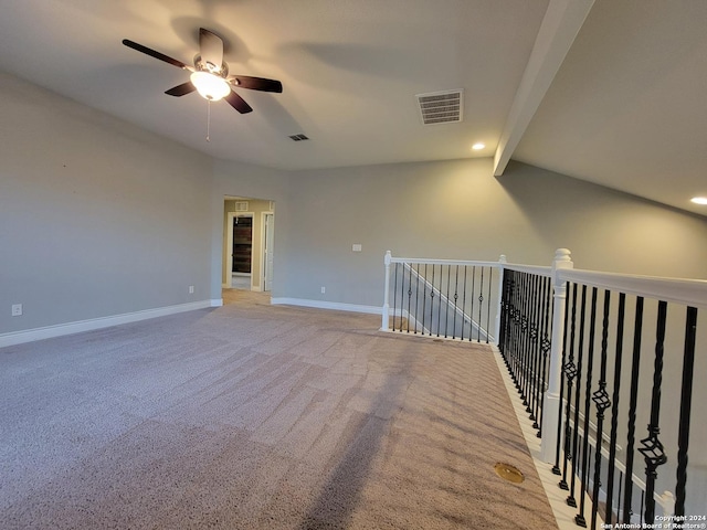 spare room featuring ceiling fan, light carpet, and lofted ceiling with beams