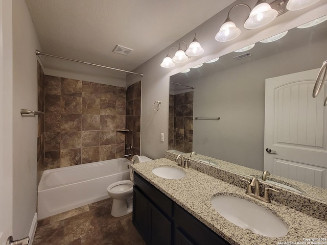 full bathroom with tiled shower / bath combo, toilet, and vanity