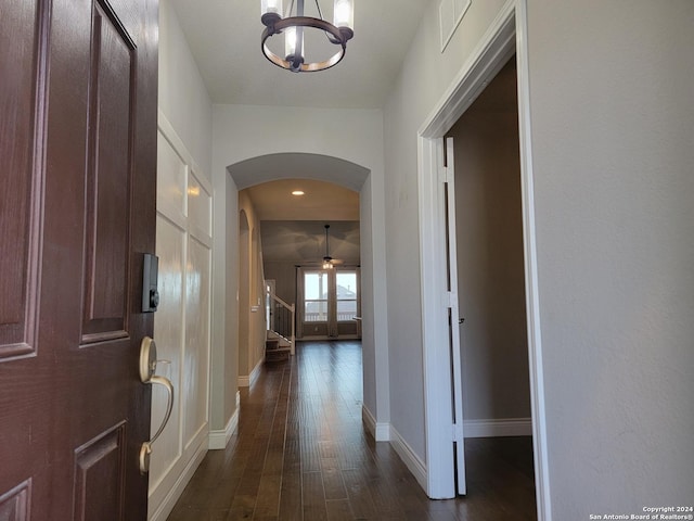 hall with a notable chandelier and dark hardwood / wood-style flooring