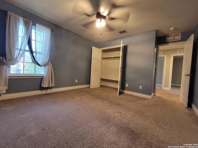 unfurnished bedroom featuring light colored carpet, a closet, and ceiling fan