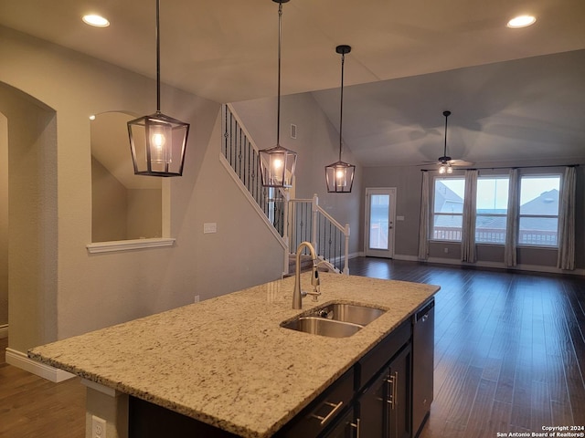 kitchen with sink, a kitchen island with sink, pendant lighting, and stainless steel dishwasher