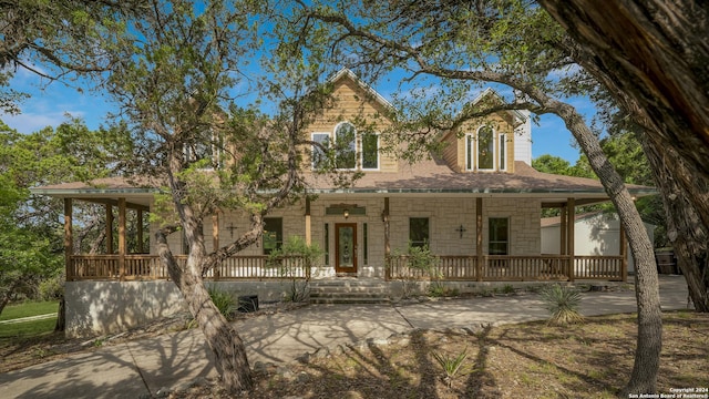 view of front of home featuring covered porch and stone siding