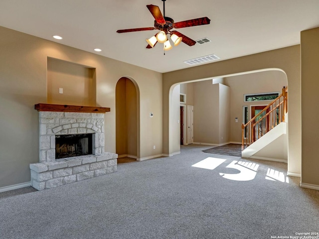 unfurnished living room with ceiling fan, a fireplace, and carpet floors