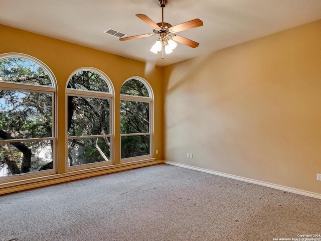 unfurnished room featuring ceiling fan and carpet