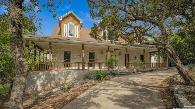 view of front of house with covered porch and stone siding