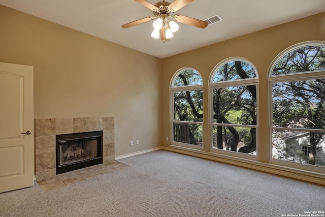 unfurnished living room featuring light carpet, ceiling fan, and a fireplace