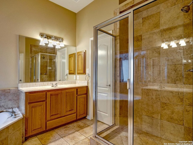 full bath featuring a stall shower, a garden tub, vanity, and tile patterned floors