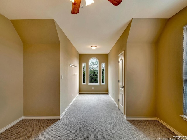 entryway featuring baseboards, a ceiling fan, and light colored carpet