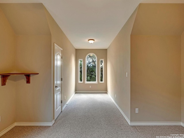 foyer featuring light colored carpet and baseboards