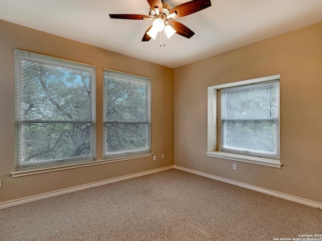 unfurnished room with carpet, ceiling fan, plenty of natural light, and baseboards