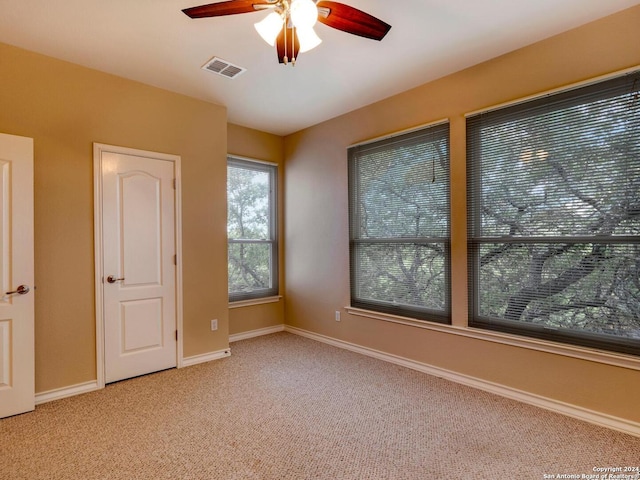 unfurnished room featuring ceiling fan and light carpet