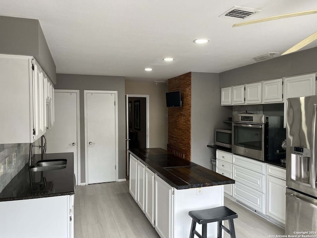 kitchen featuring tasteful backsplash, stainless steel appliances, and white cabinets