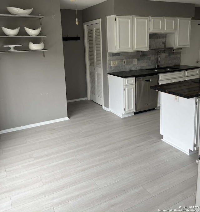 kitchen with white cabinets, dishwasher, light hardwood / wood-style floors, decorative backsplash, and sink