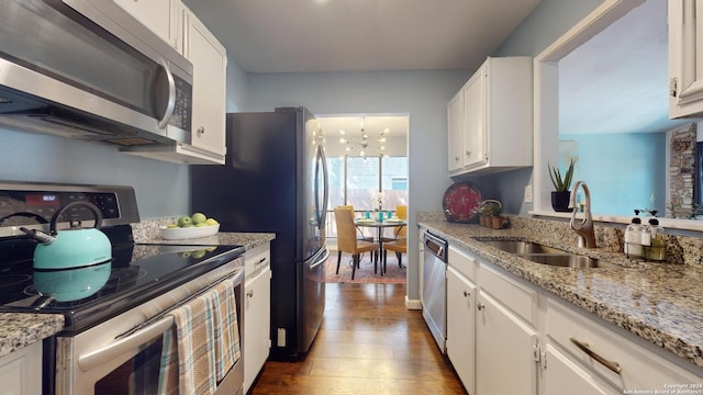 kitchen with sink, white cabinetry, an inviting chandelier, dark hardwood / wood-style floors, and stainless steel appliances