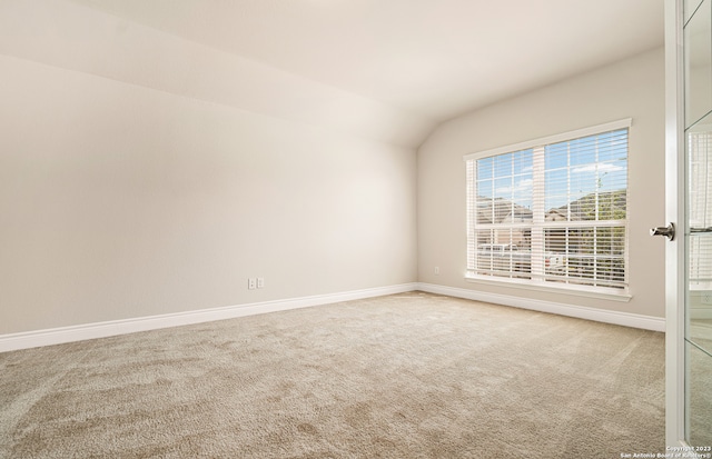 unfurnished room with carpet floors and lofted ceiling