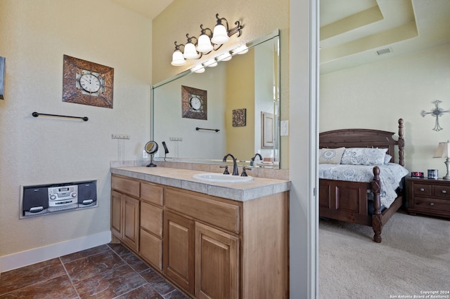 bathroom with vanity, tile patterned flooring, and a raised ceiling