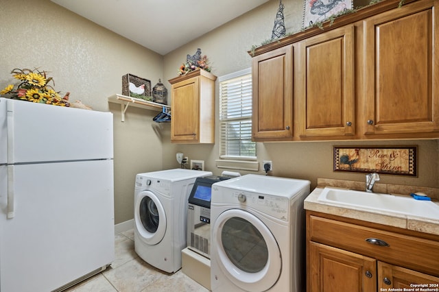 washroom featuring cabinets, independent washer and dryer, sink, and light tile patterned floors