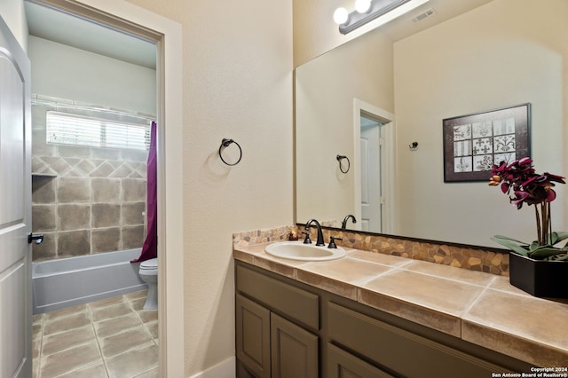 full bathroom featuring shower / bath combo with shower curtain, tile patterned floors, toilet, and vanity